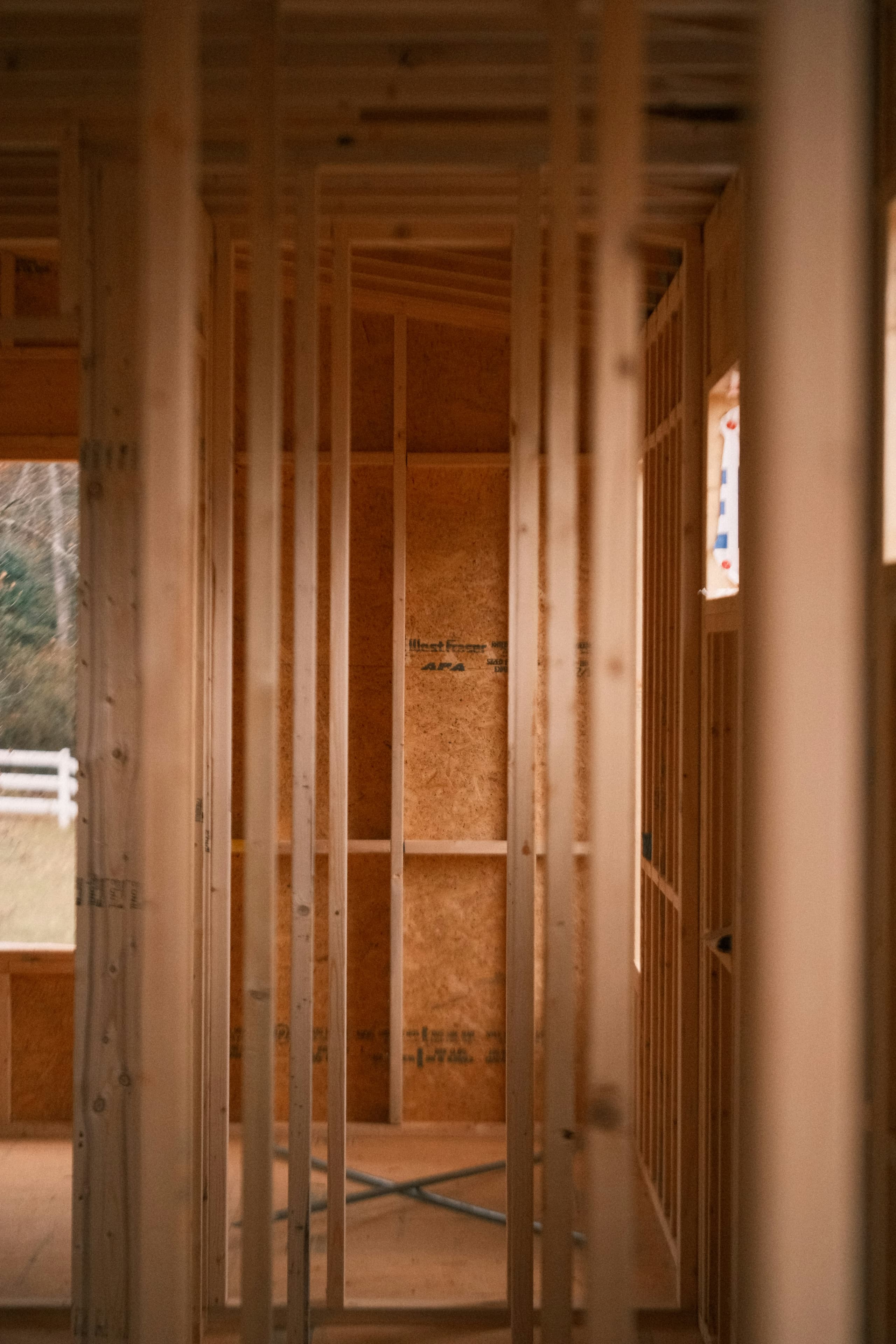 Inside a wood-framed residence — studs, plates, and sheathing ready for the trades